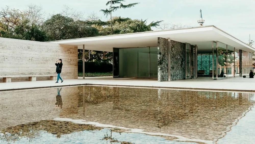Vista externa do Pavilhão de Barcelona, com sua estrutura de aço, vidro e pedra.