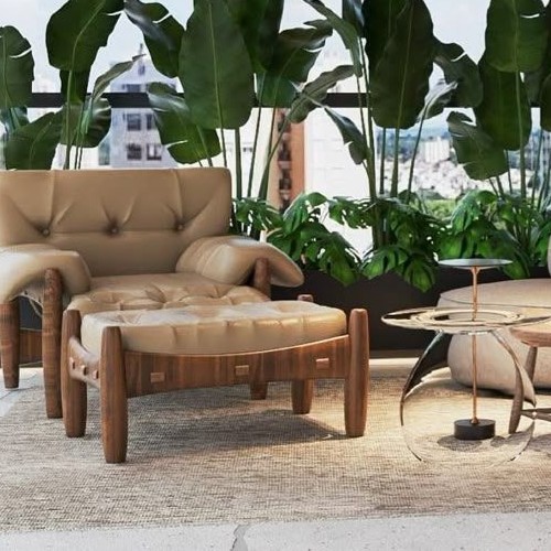 Poltrona em couro bege com pufe, emoldurada por exuberante folhagem tropical, sugerindo um refúgio urbano sustentável.