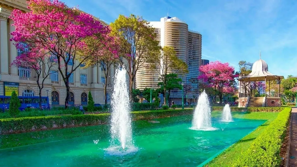 Praça da Liberdade em Belo Horizonte, com edifícios públicos de estilo neoclássico e jardins floridos.