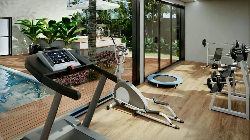 Private gym in a luxury house with a view of the outdoor area and fitness equipment.
