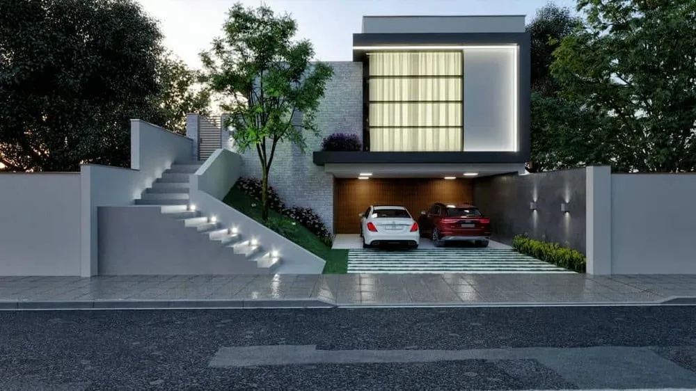 Fachada del Proyecto América, una casa moderna planeada para lote en aclive con iluminación LED.