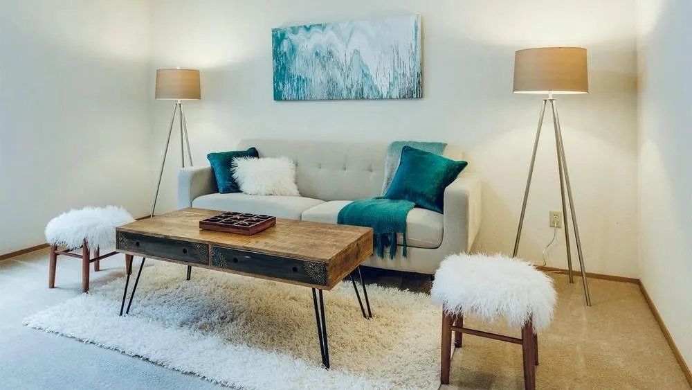 Living room with sofa, floor lamps, and a blue painting, creating a cozy and well-lit environment in a rented house.