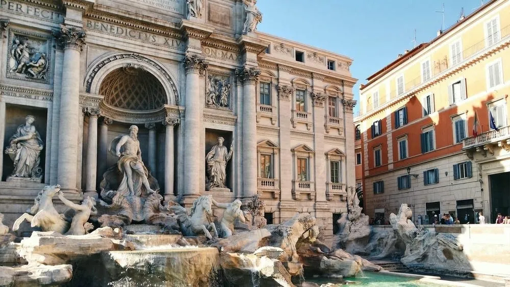 Trevi Fountain in Rome, Italy, with its baroque sculptures and surrounding buildings.