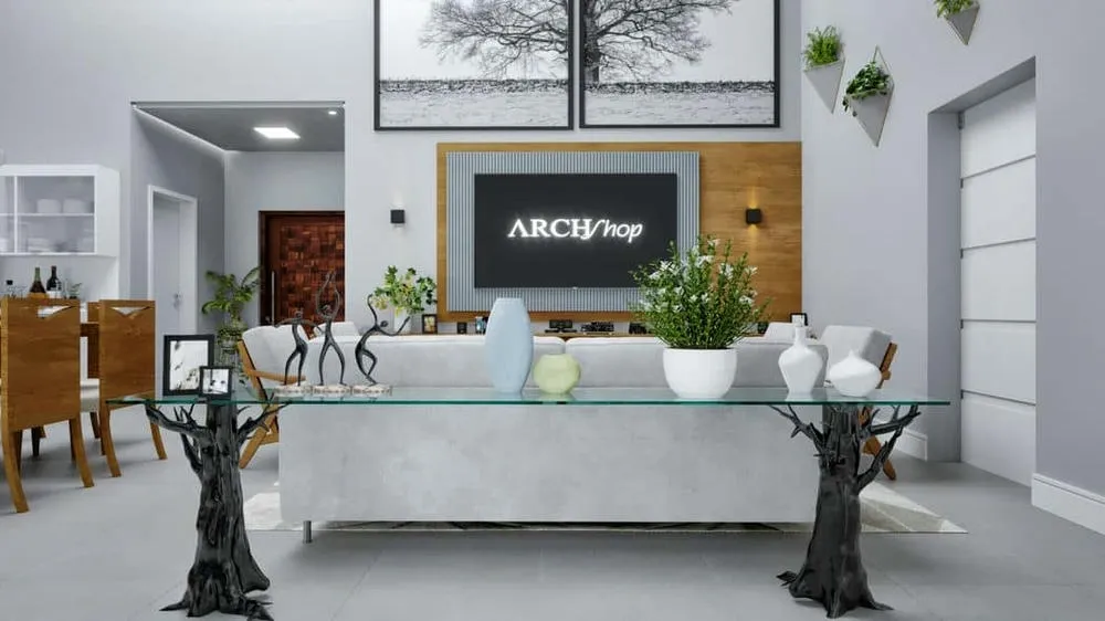 Sala de estar com sofá cinza claro, mesa de vidro com base de madeira escura e grandes quadros, evidenciando as cores naturais e o mobiliário elegante.