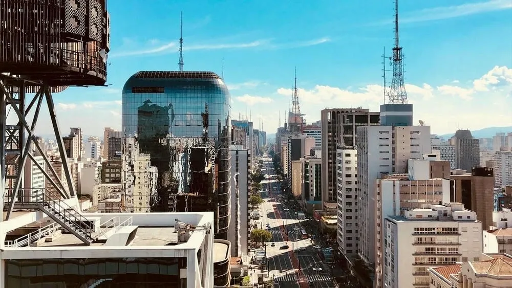 Aerial view of Avenida Paulista in São Paulo, with tall buildings and car traffic.