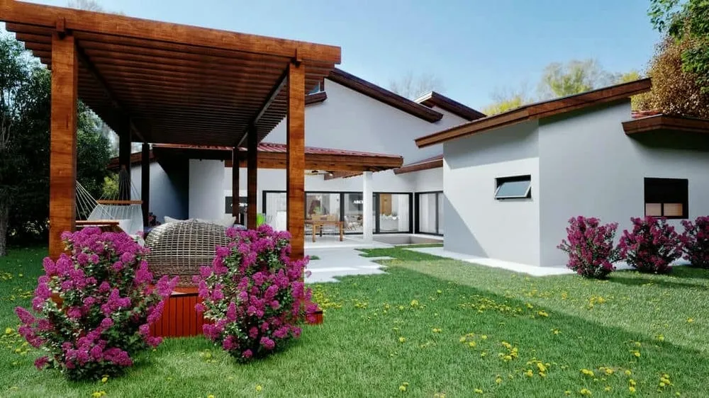Modern facade of a single-story house with an exposed roof, neutral tones, and a well-maintained lawn.