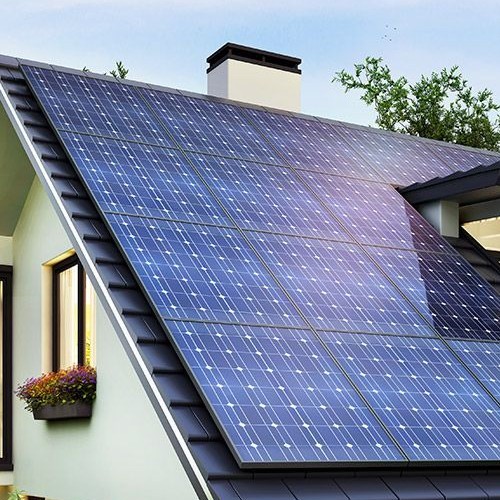 Imagem de um telhado com painéis solares integrados, mostrando a estética fotovoltaica em uma casa moderna com chaminé e uma janela com flores.