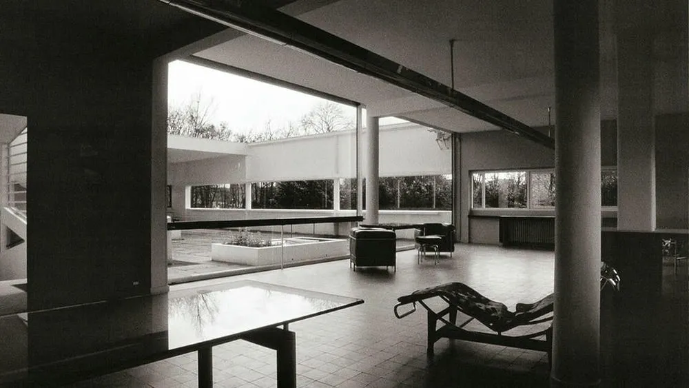Black and white interior of Villa Savoye, showing the open plan concept with large openings and thin pillars.